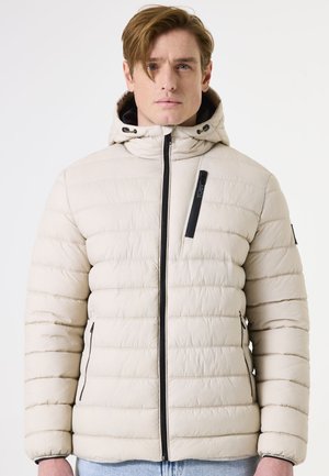 Chaqueta de plumas de color beige claro con diseño acolchado horizontal, cierre con cremallera en la parte delantera y capucha ajustable. Presenta acentos negros y bolsillos.