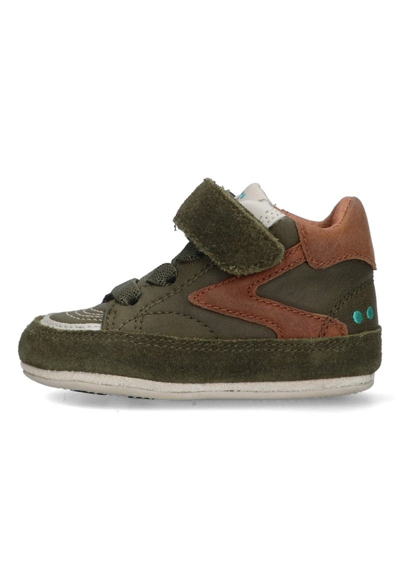 Donkergroene suède sneaker met een bruin leren accent, witte zool, verstelbare band en textuurdetails op de neus.