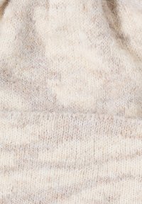 Licht beige gebreide beanie met een zachte textuur, voorzien van een subtiel gemêleerd patroon en een omgeslagen rand aan de onderkant.
