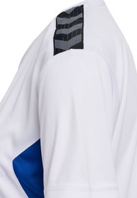 Vit idrottströja med en blå detalj på sidan och en texturerad svart accent på axeln. Tillverkad av ett mjukt och andningsbart material.