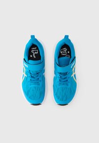 Μπλε αθλητικά παπούτσια με υφασμάτινο πλεκτό επάνω μέρος, λευκό ενδιάμεσο πέλμα και μαύρη εξωτερική σόλα. Διαθέτουν ιμάντα με βέλκρο και διακοσμητικό εσωτερικό σχέδιο στο πέλμα.