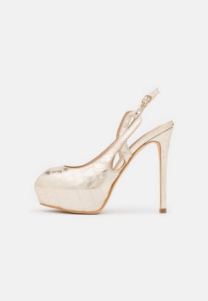 Guld højhælet slingback sko med tekstureret mønster, rund snude og ankelrem med spænde, vist fra siden på hvid baggrund.