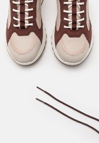 Zapatillas de cuero y ante en beige, marrón y rosa suave con cordones en contraste. Acabados texturizados y suelas de goma blancas realzan el diseño.