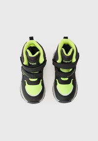 Svarte og neongrønne høyhælte sneakers med borrelås, teksturert nettstoff og gummisåler, med avrundet tå og trekkstang.