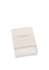 Liten, öppen vit box med guldtexten "amor" på locket, tom inuti, visad mot en vit bakgrund.