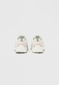 Bílé a světle šedé sportovní boty s síťovanými panely, polstrovaným límcem a strukturovanými podrážkami. Minimalistický design s kontrastními detaily.