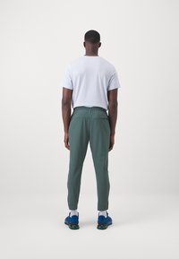 Nike Performance UNLIMITED PANT - Treningo apatinė dalis - vintage green/black