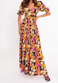 Robe maxi à motif floral présentant des teintes de rose, d'orange et de jaune sur un fond noir. Manches courtes bouffantes et taille cintrée.