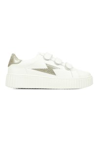 Baskets blanches avec trois bandes Velcro, une semelle texturée blanche et un accent métallique argenté au niveau du talon et un motif d'éclair sur le côté.
