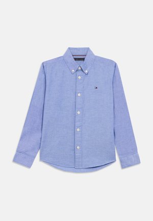 Svijetloplava košulja dugih rukava s gumbima i ovratnikom, na lijevoj strani prsnog dijela ima mali logo Tommy Hilfiger.