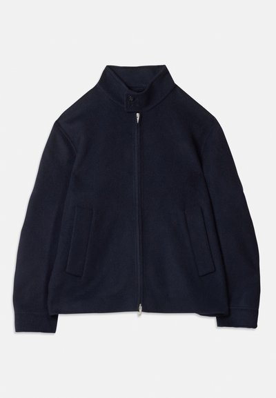 Laivansinis fleece-takki, jossa on pystykaulus, etuvetoketju, nappikiinnitys kauluksessa ja kaksi pystysuoraa etutaskua.