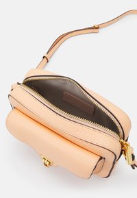 Borsa a tracolla in pelle color pesca con finitura strutturata, due scomparti con cerniera, dettagli in oro e interno foderato marrone.