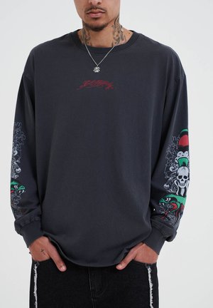 Dark gray long-sleeve shirt with red graphic text on the chest and intricate sleeves featuring colors, skulls, patterns, and snake motifs.