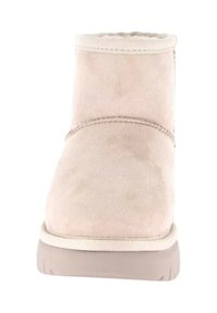 Stivaletto beige con tomaia in suede, fodera morbida e suola in gomma con texture. Presenta cuciture minime e un design della punta arrotondato.
