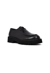 Zapato de cuero negro con punta redondeada, diseño de cordones de bajo perfil, suela de tracción de goma gruesa y textura suave.