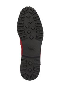 Zwarte rubberen schoenenzool met een loopvlakpatroon met diamanten vormen en richels, met een rode bovenkant die gedeeltelijk zichtbaar is.