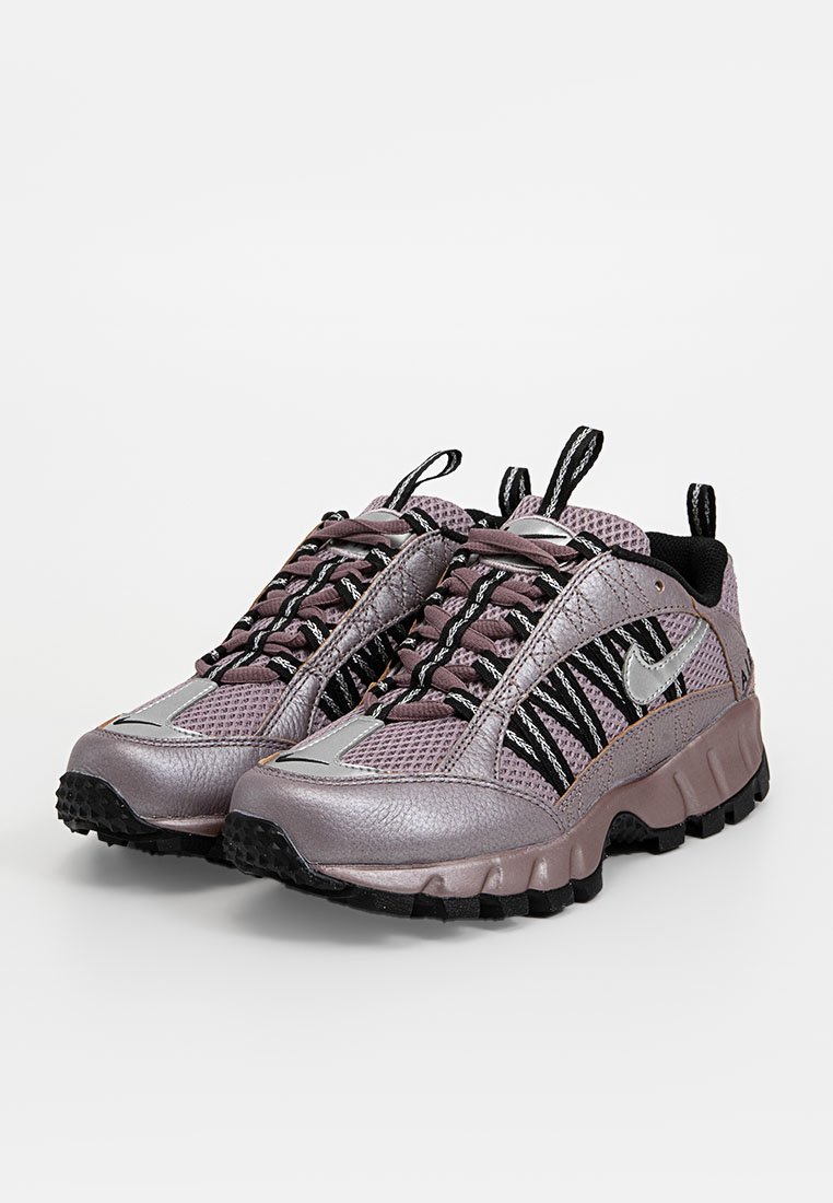 Laufschuhe mit Schnürung aus lila und schwarzem Mesh mit glänzenden silbernen Akzenten und strukturierten Gummisohlen, ausgestattet mit einem gepolsterten Schaft und Zunge.