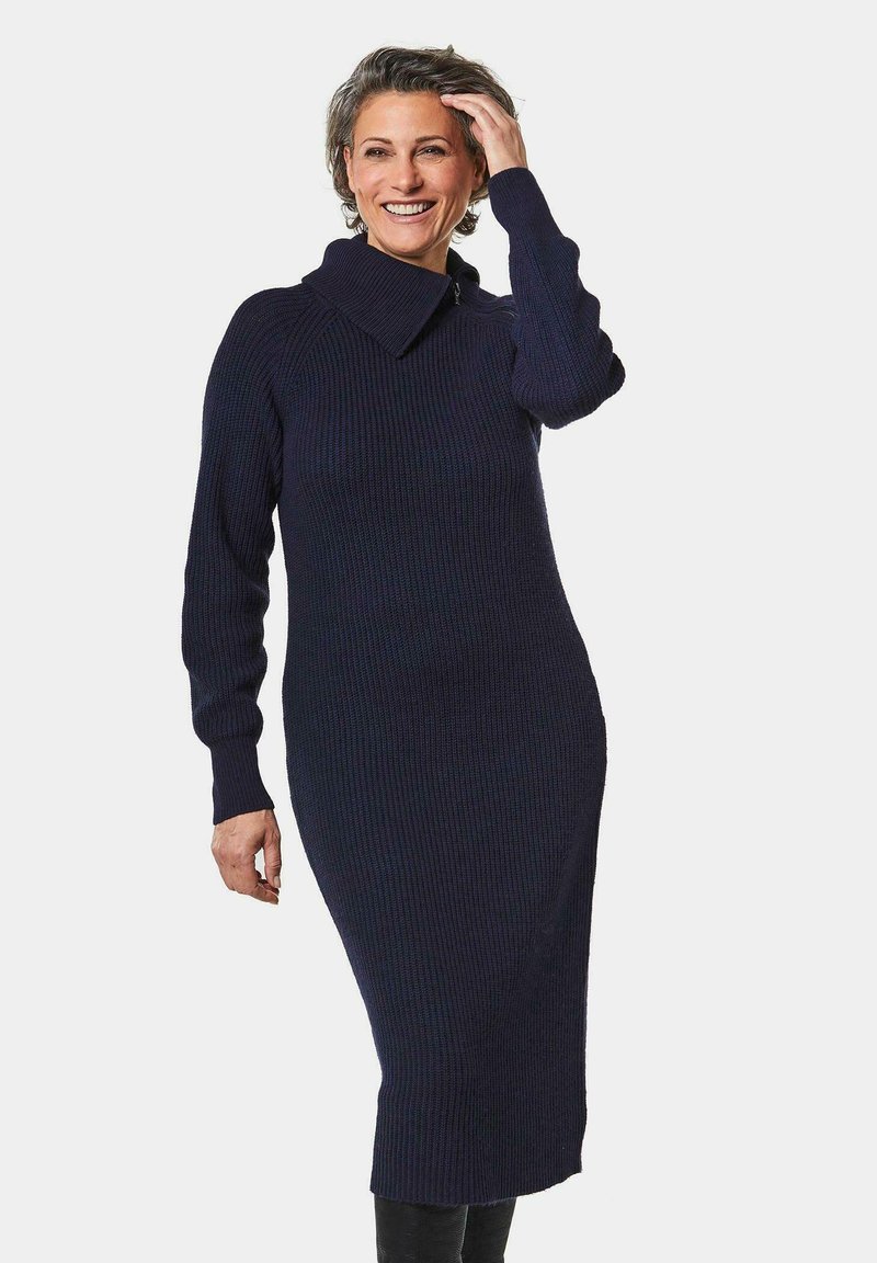 Marineblaues, geripptes Strickkleid mit weitem Kragen, langen Ärmeln und einer figurbetonten Silhouette. Weicher Stoff und mittellanges Design, ideal zum Schichten.