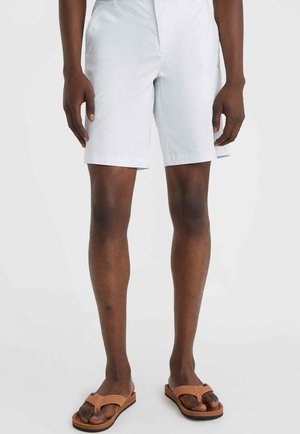 White shorts made of lightweight fabric, featuring a straight cut and side pockets. Paired with brown flip-flops.