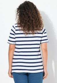 Marineblauw en witte gestreepte t-shirt met korte mouwen, een ronde halslijn en een relaxte pasvorm. Katoenen materiaal met een gladde textuur.