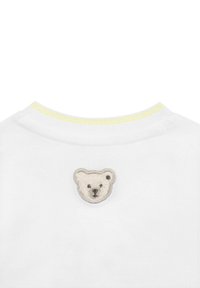 Weißes Sweatshirt mit Rundhalsausschnitt, ausgestattet mit einem gelb gestreiften Kragen und einem weichen, gestickten Bärenpatch auf der Rückseite.