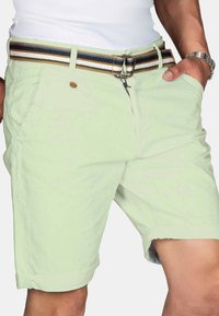 Light green shorts with a belt featuring brown, black, and white stripes. Includes front pockets and a zipper closure.