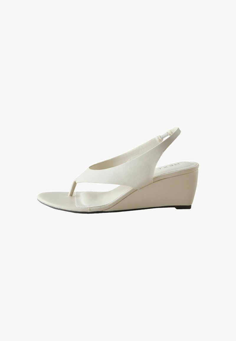 Sandale compensée beige avec bout ouvert, bride arrière et avant en style tongs. Tige lisse avec légère brillance sur le talon compensé.