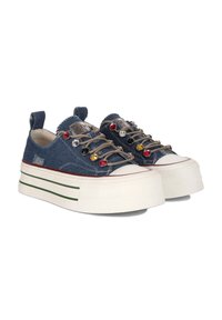Sneakers na platformie z denimu mają ciemnoniebieską cholewkę, akcenty z srebrnych i kolorowych kamieni na sznurowadłach, kontrastową białą podeszwę oraz zielone paski.