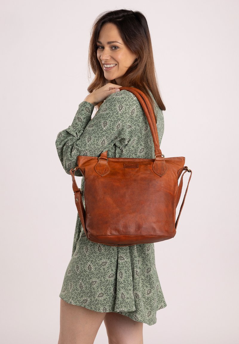 Borsa a tracolla in pelle marrone con doppie maniglie, forma rettangolare, texture liscia e spallaccio removibile. Apertura superiore con hardware minimale.