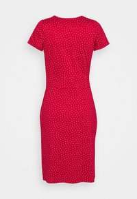 Vestito rosso a maniche corte con una forma aderente e pois bianchi. Tessuto morbido con scollatura rotonda e orlo a lunghezza ginocchio.