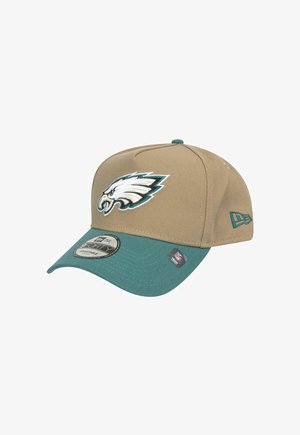 Beige Baseballkappe mit einem türkisfarbenen Schild, mit einem weißen und türkisgestickten Adler-Logo auf der Vorderseite. Verstellbare Passform, aus Stoff gefertigt.