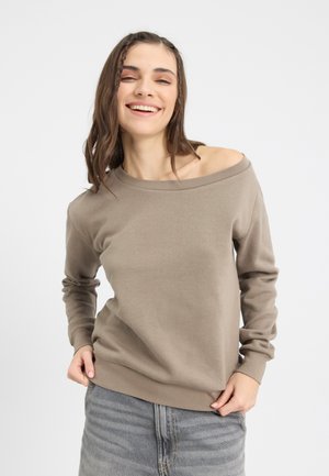 Sweatshirt marron décolleté avec des manches longues, texture douce, poignets côtelés, associé à un jean en denim gris clair.