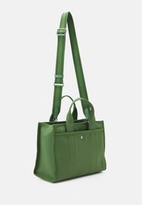 Sac d’épaule rectangulaire en toile verte avec bandoulière réglable, double poignée supérieure et poche avant à bouton-pression.