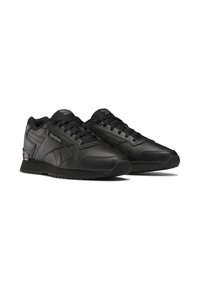Czarne buty sportowe z gładką skórzaną cholewką, z teksturowanymi akcentami, okrągłym noskiem, płaskimi sznurowadłami oraz gumową podeszwą z małymi bieżnikami.