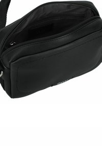 Bolso de cuero negro tipo bandolera con una textura suave, que cuenta con un compartimento principal con cremallera y un bolsillo frontal plano para almacenamiento adicional.