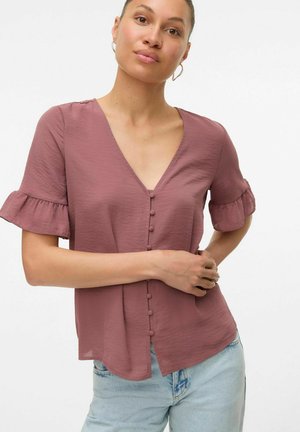 Kortærmet bluse med V-hals i støvet rose, med knaplukning foran, rynkede ærmer og let tekstur. Kombination med lyseblå jeans.