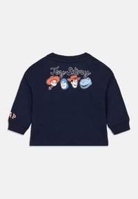 Μπλε ναυτικό βαμβακερό πουκάμισο με μακριά μανίκια, με χαρακτήρες κινουμένων σχεδίων από το Toy Story στην πλάτη, με το κείμενο "Toy Story" πάνω από τα γραφικά.