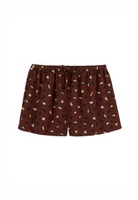 Shorts courts marron avec une taille élastique et un cordon de serrage. Présentent un imprimé léopard avec des taches noires et beiges sur le tissu.