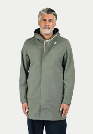 Cappotto impermeabile verde con cappuccio, chiusura con zip e un accento del logo bianco sul petto. Tessuto liscio, progettato per l'abbigliamento outdoor.