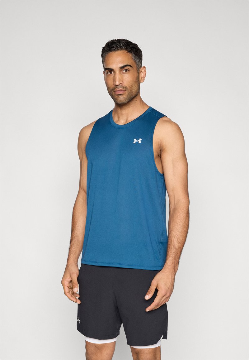 Maglietta atletica senza maniche blu realizzata in tessuto morbido, abbinata a pantaloncini neri con bordo bianco, mostrata su uno sfondo semplice.