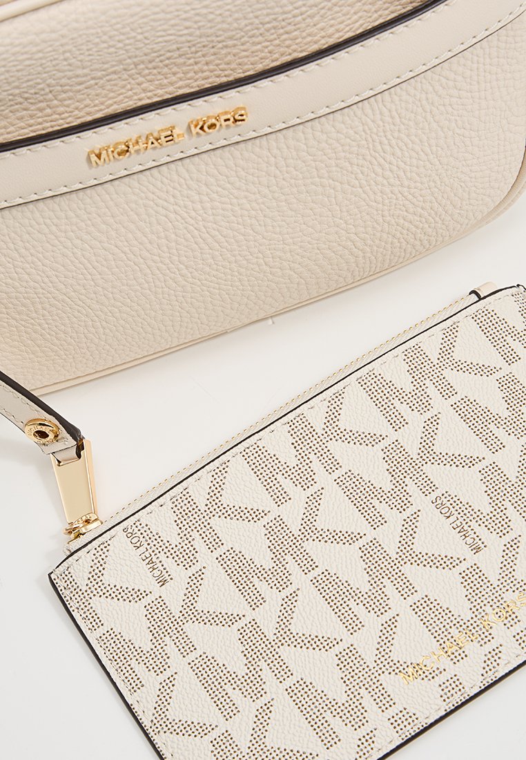 Beige Lederhandtasche mit Struktur und goldenen Beschlägen. Enthält einen abnehmbaren Kartenhalter mit einem durchbrochenen MK-Logo-Muster.