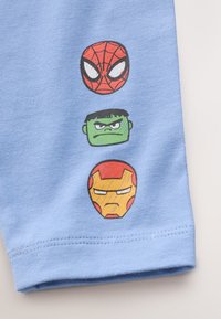 Tissu bleu clair orné de visages de dessins animés imprimés de Spider-Man, Hulk et Iron Man en rouge, vert et jaune respectivement.