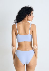 Lyseblå ribbet bikini-sett med justerbare stropper. Toppen har en rektangulær form, mens bunnene er lavt skåret og glatte.
