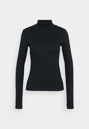 Svart ribbet langermet genser med høy hals og tilpasset silhuett på en ensfarget lys bakgrunn.