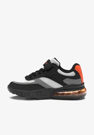Zapatilla deportiva negra, blanca, gris y naranja con cordones delanteros, tira de velcro, paneles de malla y suela visible con amortiguación de aire.
