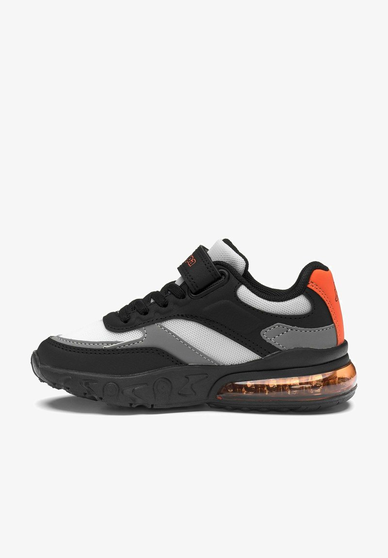 Zapatilla deportiva negra, blanca, gris y naranja con cordones delanteros, tira de velcro, paneles de malla y suela visible con amortiguación de aire.