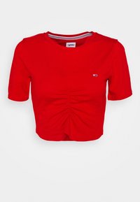 Camiseta roja corta con mangas cortas, que presenta un detalle fruncido en el frente y un pequeño logo en el pecho. Material de algodón con un escote redondo.