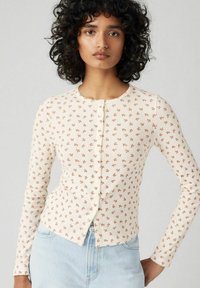 Langärmeliges Cardigan aus cremefarbenem Rippstoff mit floralem Muster in rostrot und rundem Ausschnitt mit Knopfverschluss vorne.