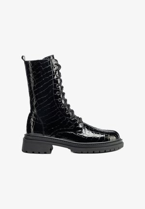 Černá lesklá vojenská kotníková bota z umělé krokodýlí kůže s předním zavazováním na tkaničky, poutkem na patě a robustní drážkovanou podešví.