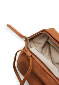 Borsa a mano in pelle marrone con chiusura a zip, fodera interna beige e tracolla piatta. Presenta una forma rettangolare e una superficie texturizzata.